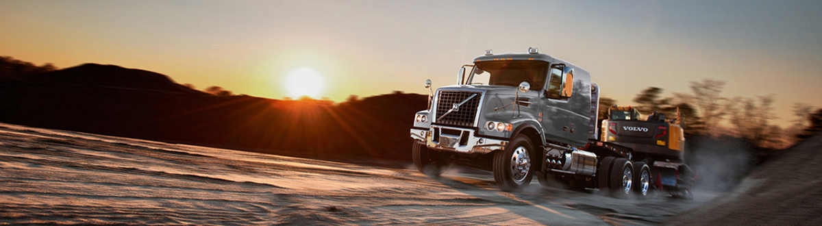 Silver Volvo® truck driving through a snowy road.